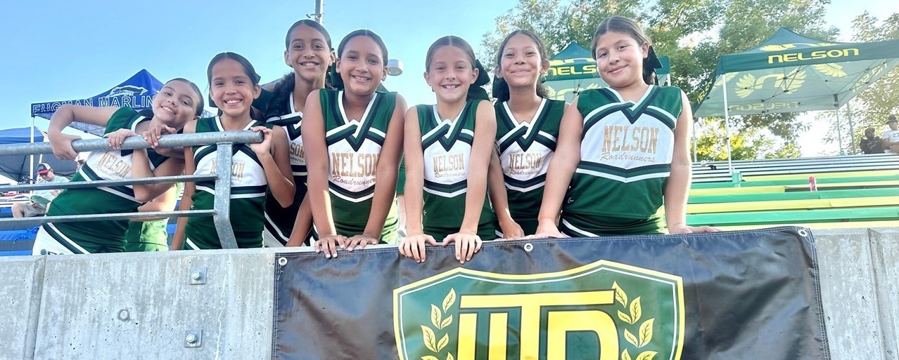 cheerleaders smiling above Nelson banner